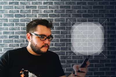 Anatoli Nicolae looking at a smartphone with an app icon overlay