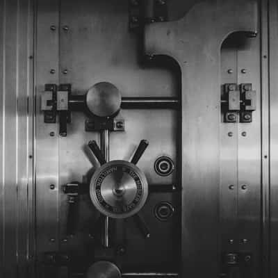 Close-up of a steel bank vault door with combination lock